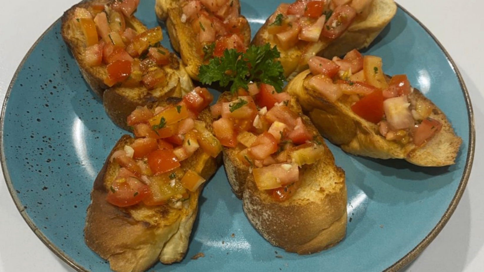 Fresh tomato bruschetta on a blue ceramic plate