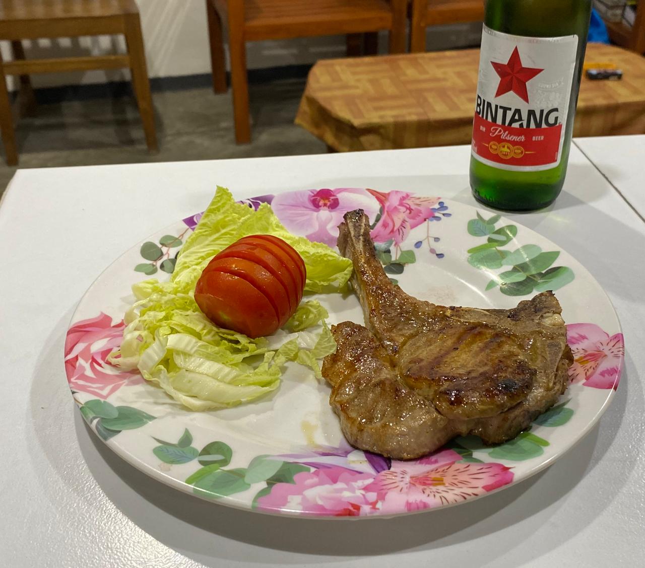 Grilled pork chop with salad and a cold Bintang beer